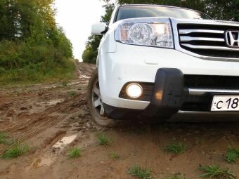 Белый Honda Pilot 2 едет по плохой дороге и грязи
